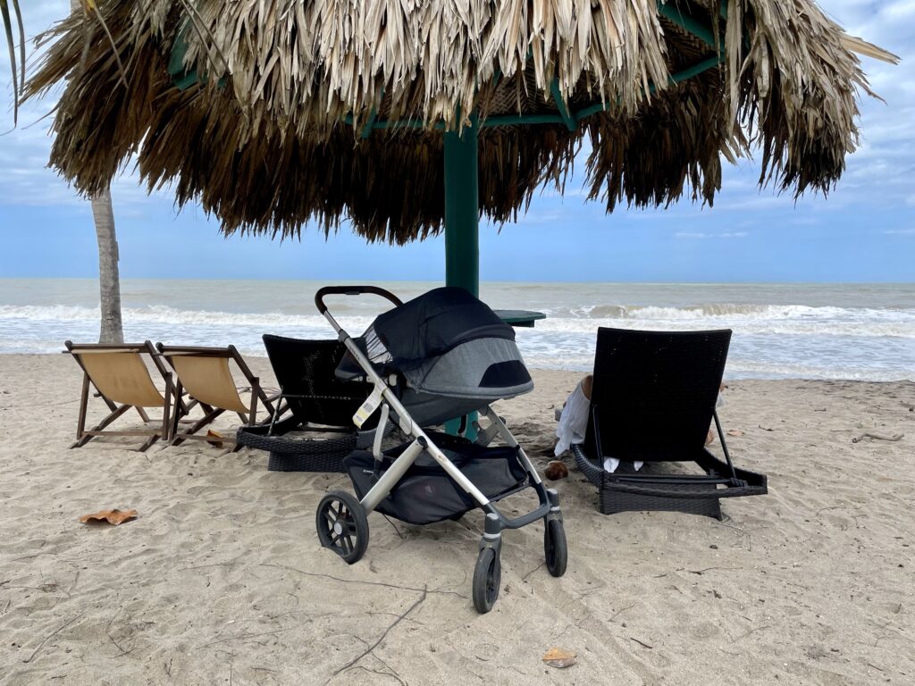 an Uppababy Vista V2 with its seat looking backwards on a sandy beach.